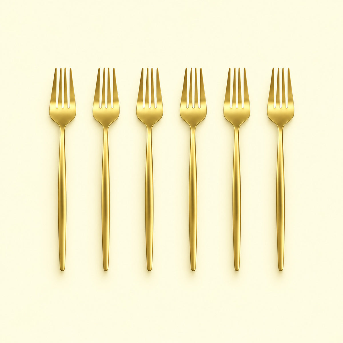 Set of six gold dinner forks on a pale yellow studio background.