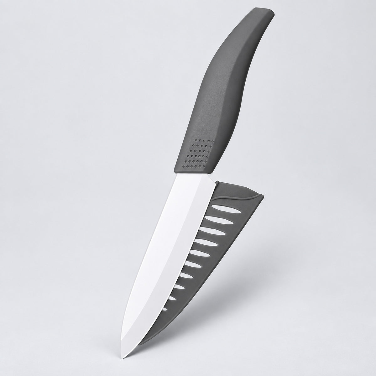 A kitchen knife with a silver blade and a dark gray handle, shown alongside its matching dark gray sheath on a light gray background.