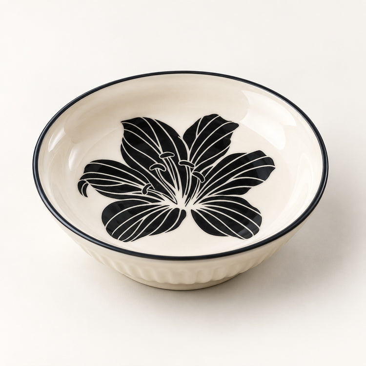An off-white ceramic bowl with a black floral design printed inside and a thin black rim, shown on a clean white background.