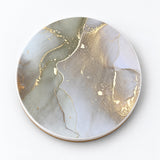 One pale gray and gold marble printed ceramic coaster on a light studio background.