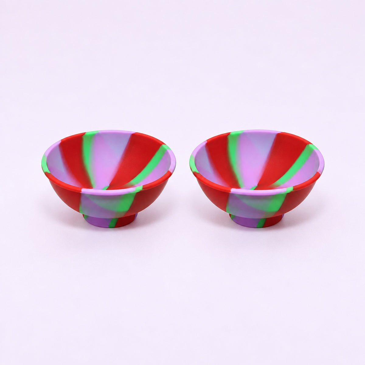 Two red purple and green swirl silicone mini bowls, open tops and pedestal bases.