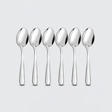 Six silver teaspoons on a pale gray studio background.
