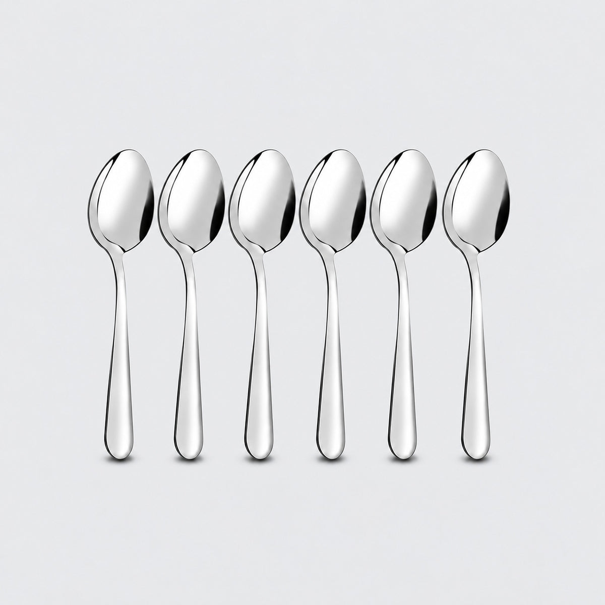 Six silver teaspoons on a pale gray studio background.