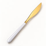 One white and gold dinner knife on a soft studio background.