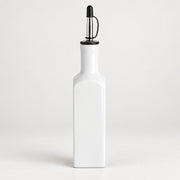 A white ceramic bottle with a black metal and plastic pour spout, shown against a clean white background.