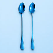 Two metallic blue spoons with a reflective finish, standing vertically side-by-side on a light blue background.