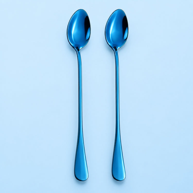 Two metallic blue spoons with a reflective finish, standing vertically side-by-side on a light blue background.