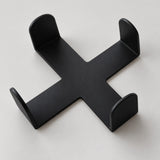 One empty black cross-shaped coaster holder, coasters sold separately.