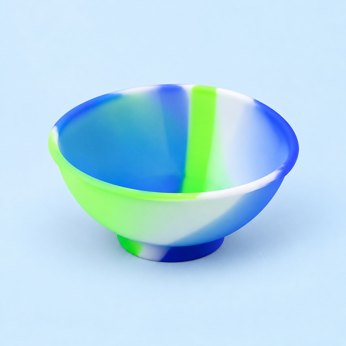 Blue, green and white mini silicone bowl, single empty piece in studio.