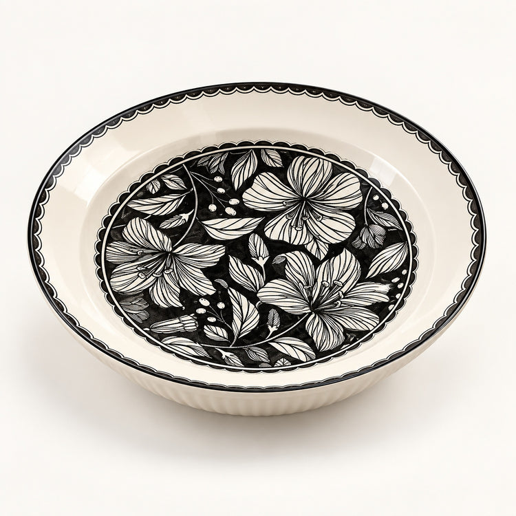 An oval ceramic bowl with a black and white floral pattern on the inner surface and a black scalloped rim, shown on a clean white background.