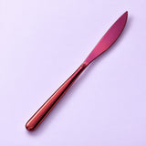 One purple dinner knife on a soft studio background.