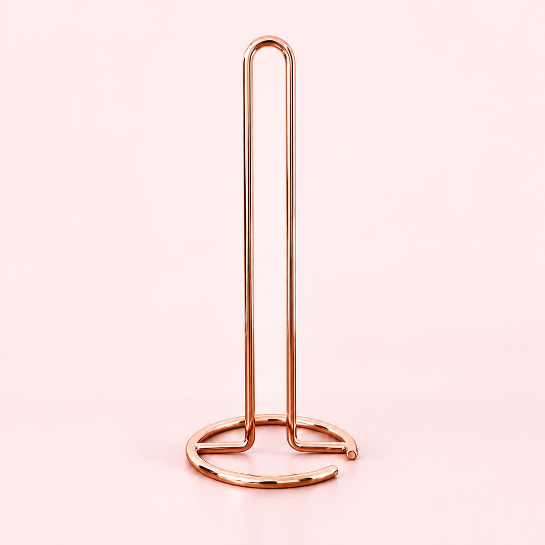 Empty rose-gold upright paper towel stand with open wire base.