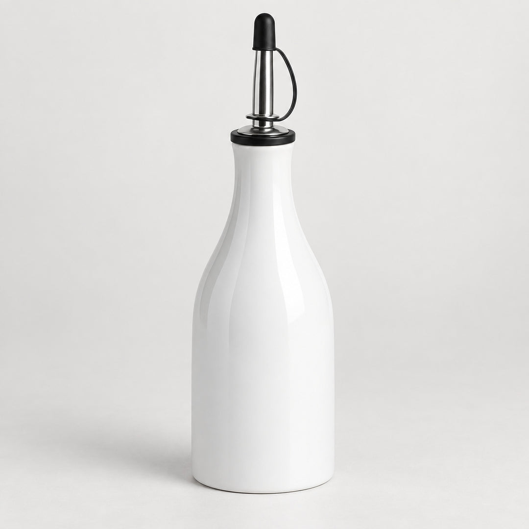 A white ceramic oil dispenser bottle with a polished stainless steel pour spout and a black plastic cap, set against a clean light gray background.