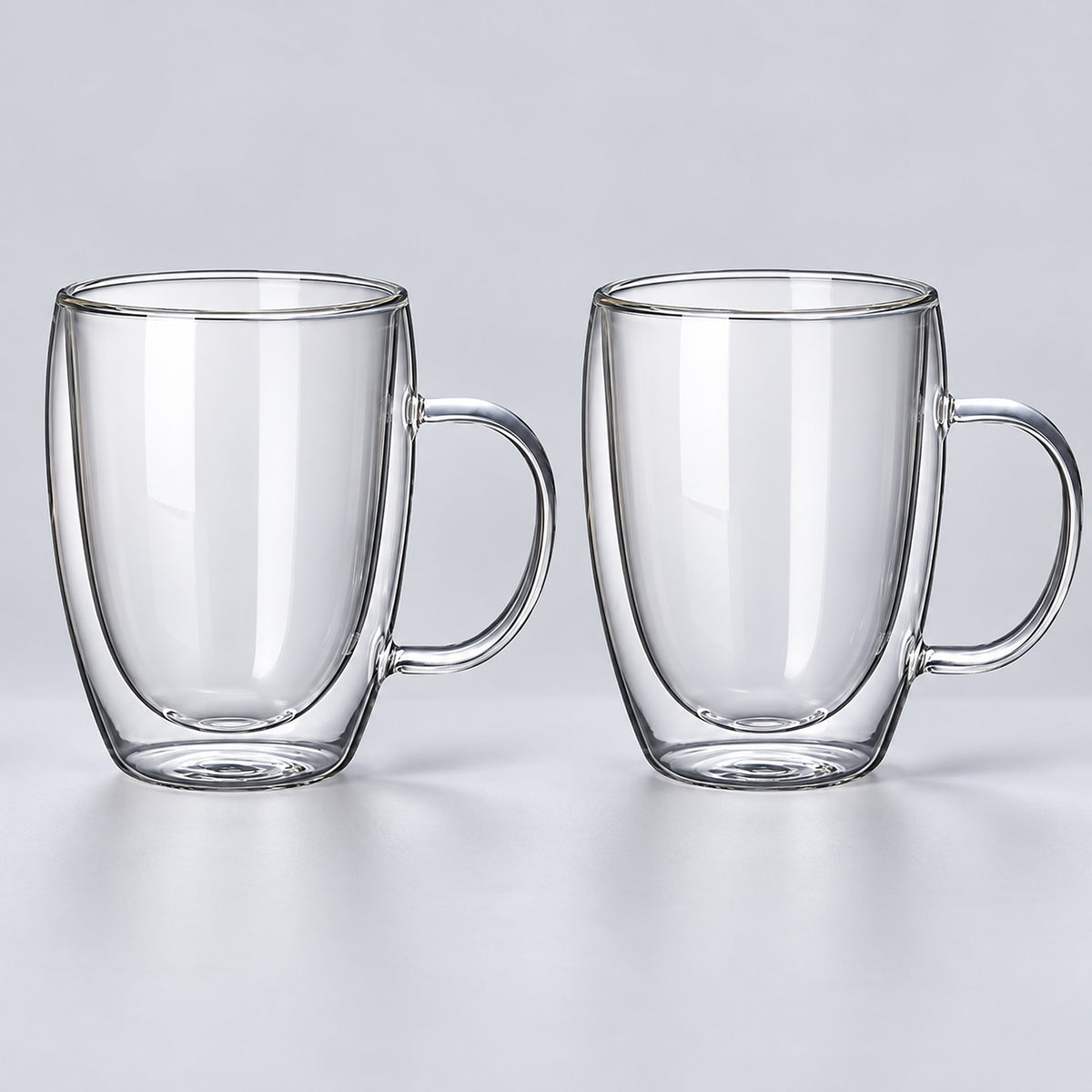 Two empty tall 450 ml clear double-wall glass mugs with handles.