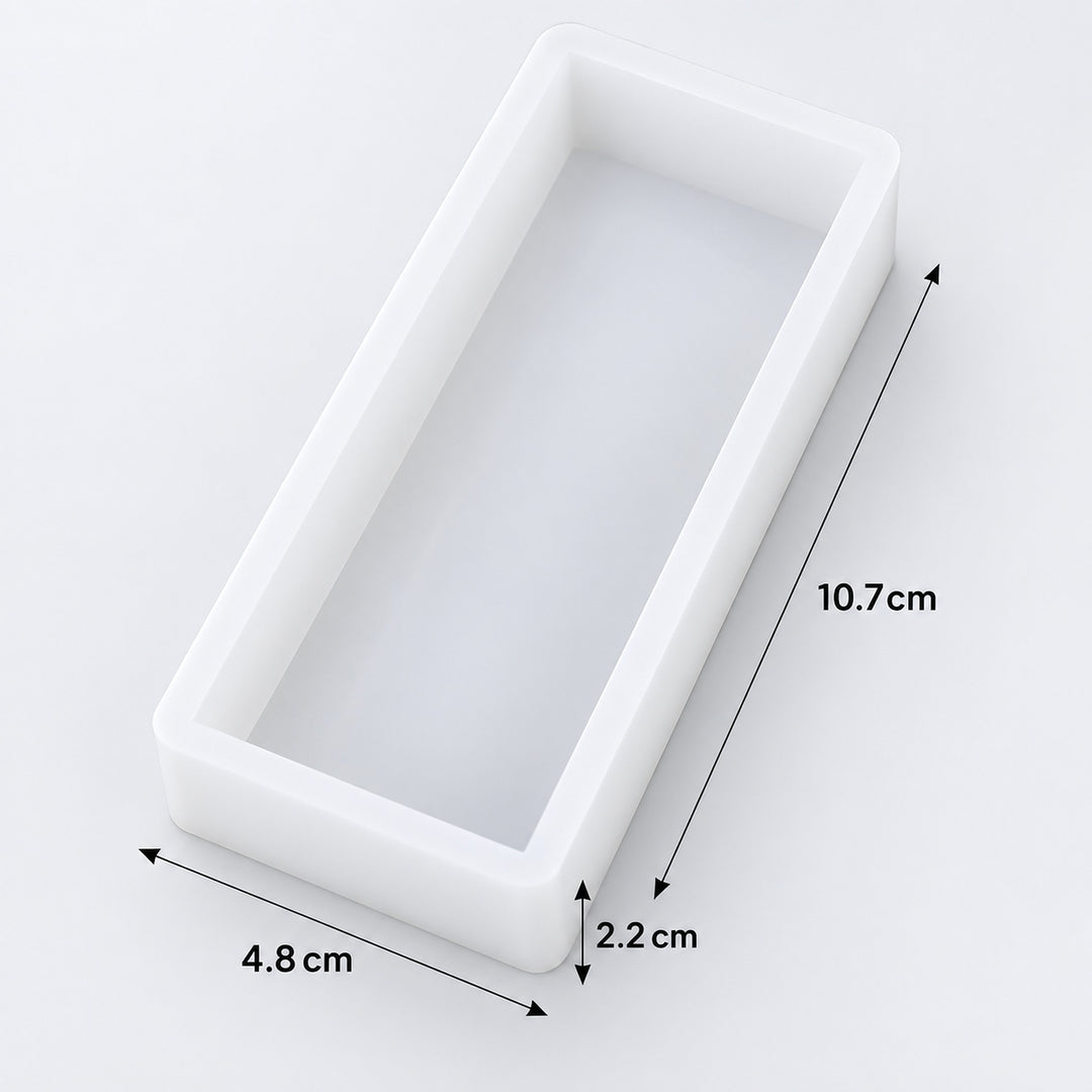 A white rectangular tray or mold shown on a light gray background with dimension arrows and labels indicating 10.7 cm length, 4.