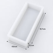 A white rectangular tray or mold shown on a light gray background with dimension arrows and labels indicating 10.7 cm length, 4.