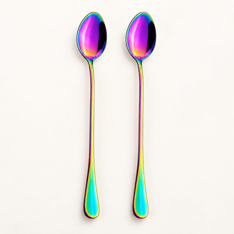 Two long spoons with an iridescent rainbow finish, standing upright against a clean off-white background.