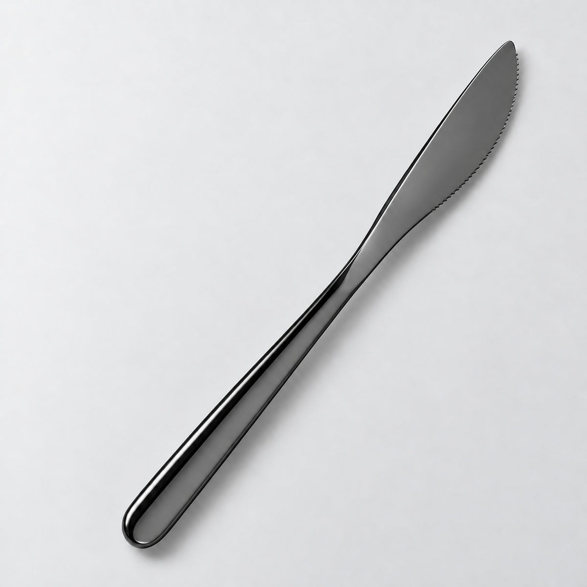 One black dinner knife on a soft studio background.