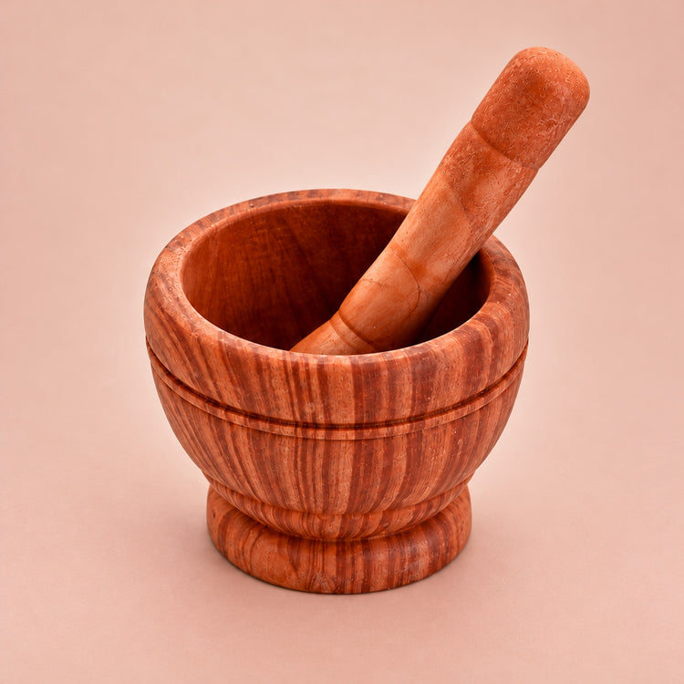 Dark Brown variant: one brown patterned mortar and matching pestle on a lighter warm studio background.