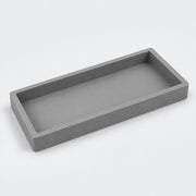 A minimalist rectangular tray with a matte gray finish, shown from an elevated perspective on a clean white background.