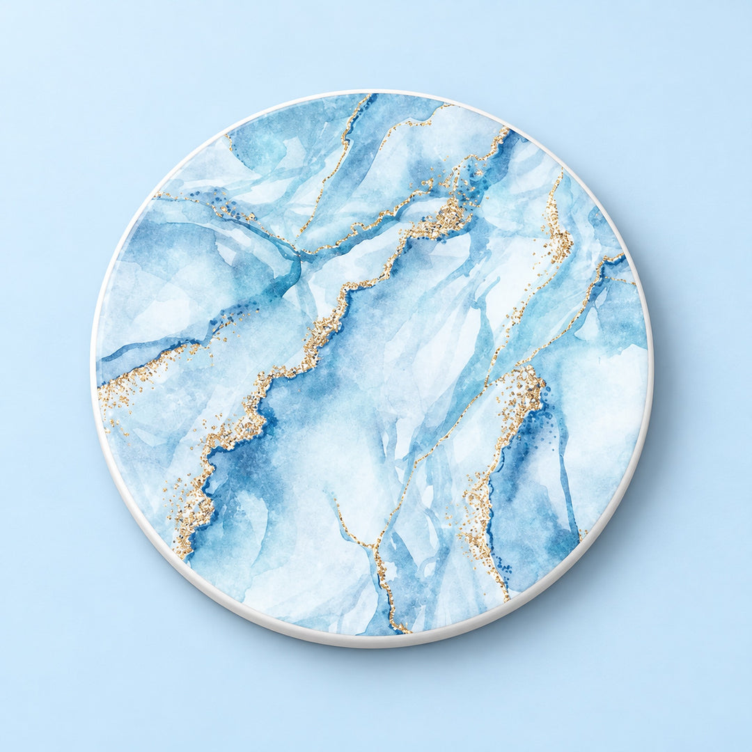 One light blue and gold marble printed ceramic coaster on a light studio background.