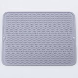 Light gray wavy-ridge silicone mat with two hanging holes.