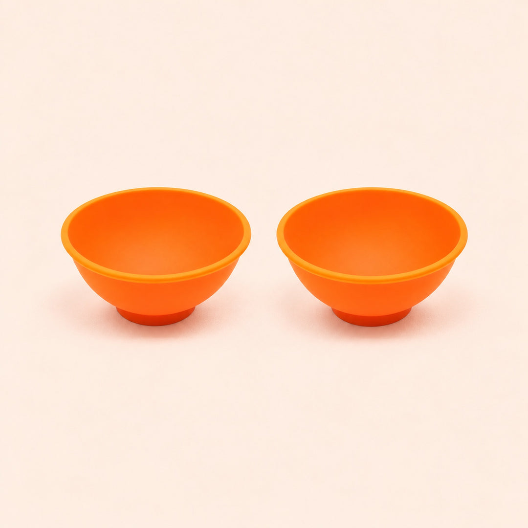 Two orange silicone mini bowls, open tops and pedestal bases.