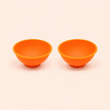Two orange silicone mini bowls, open tops and pedestal bases.