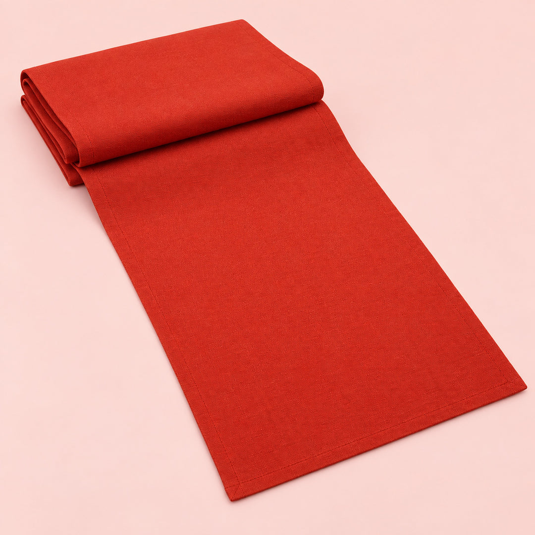 Red cotton table runner with sewn edges, folded studio view; choose length separately.