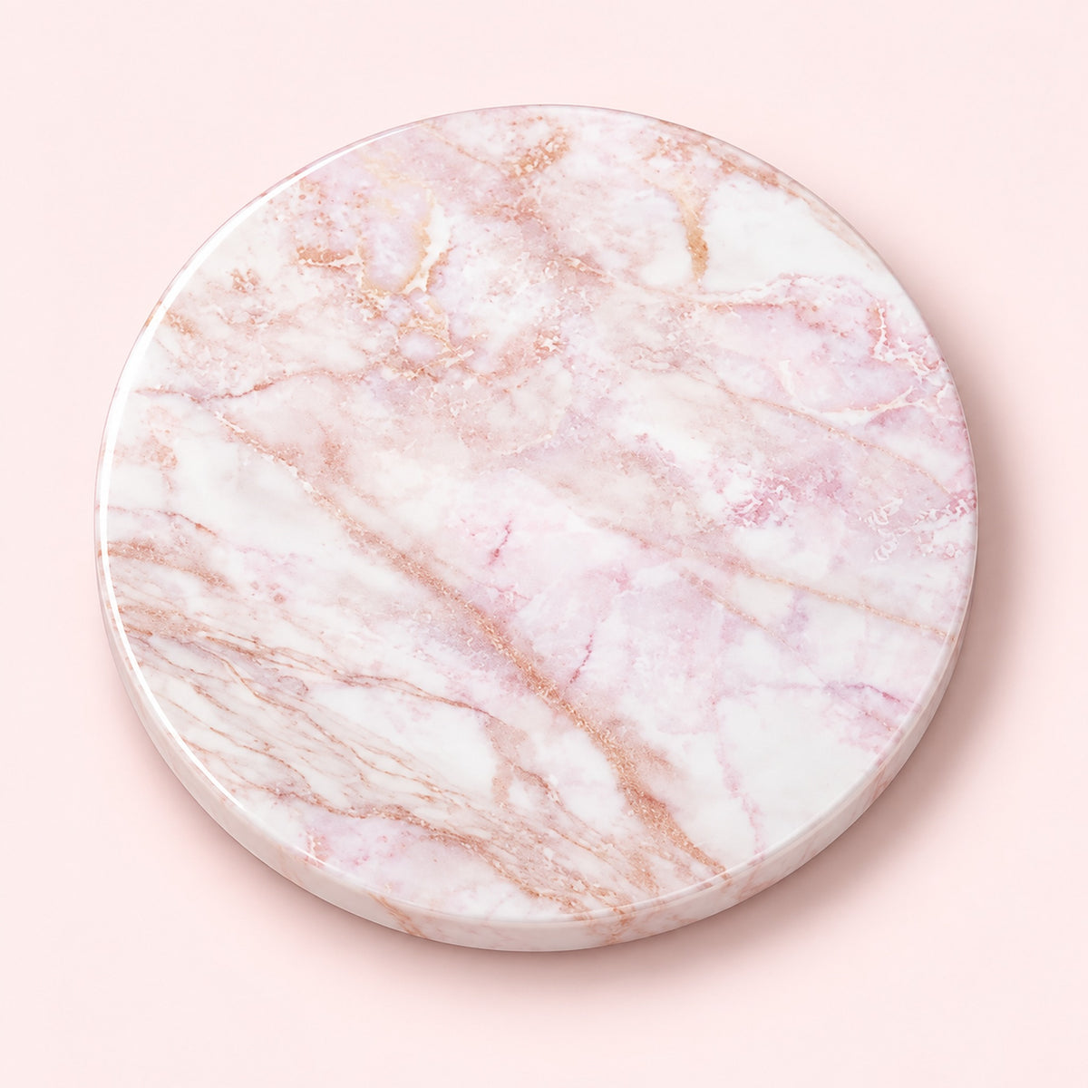A round marble coaster with a white and light pink base and delicate rose gold veining, shown from a top-down view on a solid pale pink background.