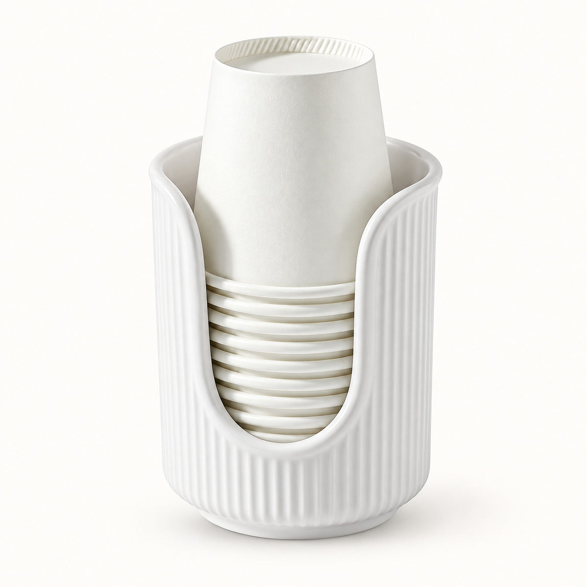 A white ribbed cup holder cradling a stack of white paper cups, photographed against a seamless white background.