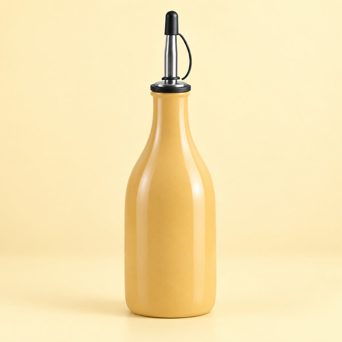 A glossy mustard-yellow glass bottle with a black and stainless steel pour spout, set against a solid pale yellow background.