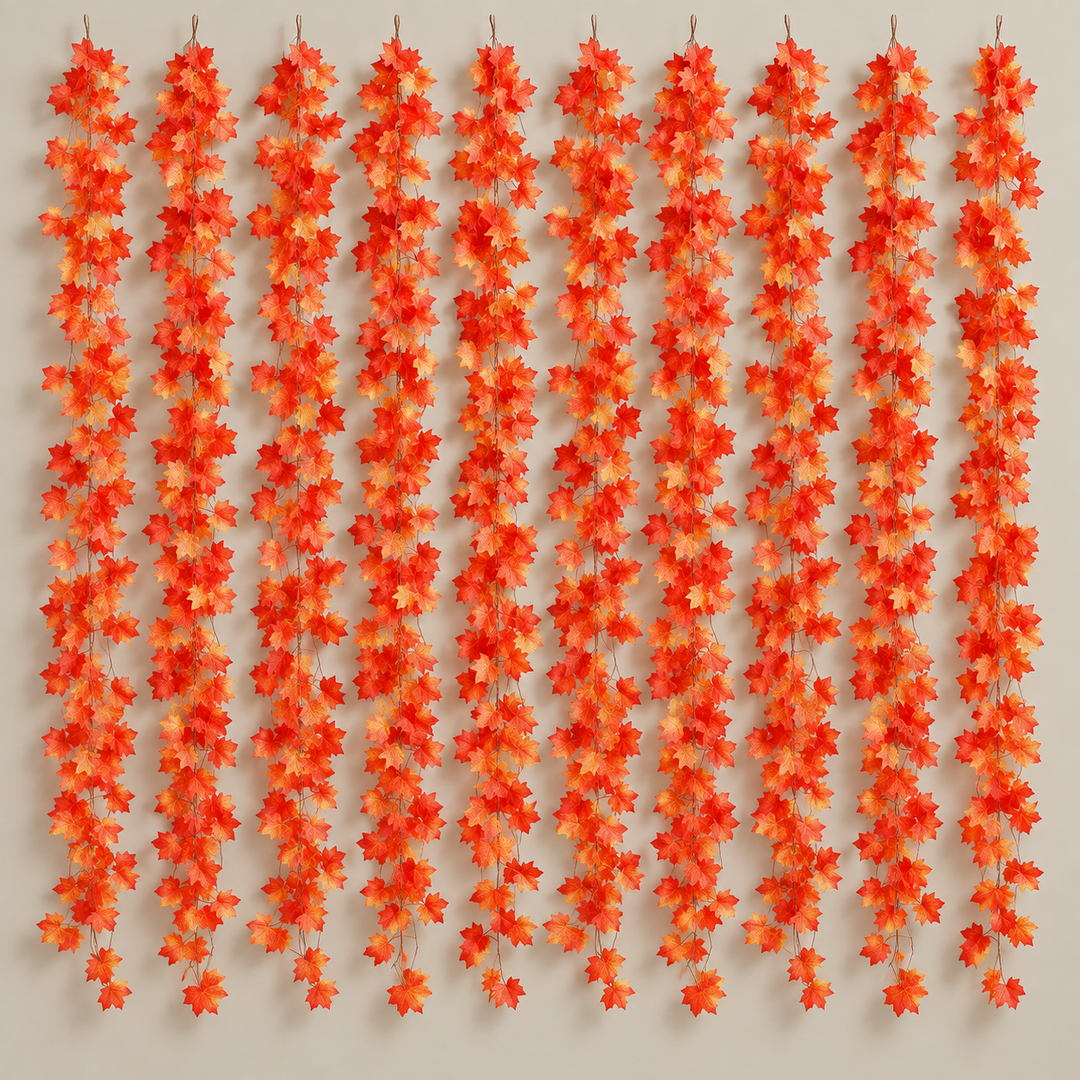 Ten artificial maple leaf garland strands hung side by side on a warm neutral wall