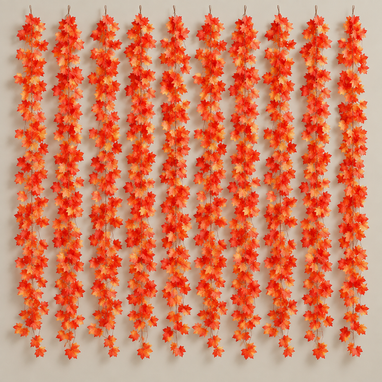 Ten artificial maple leaf garland strands hung side by side on a warm neutral wall