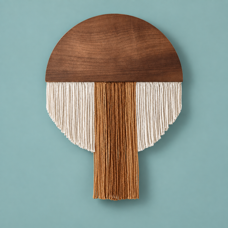 Dark wood half round with cream and rust fringe and a center tongue, teal wall