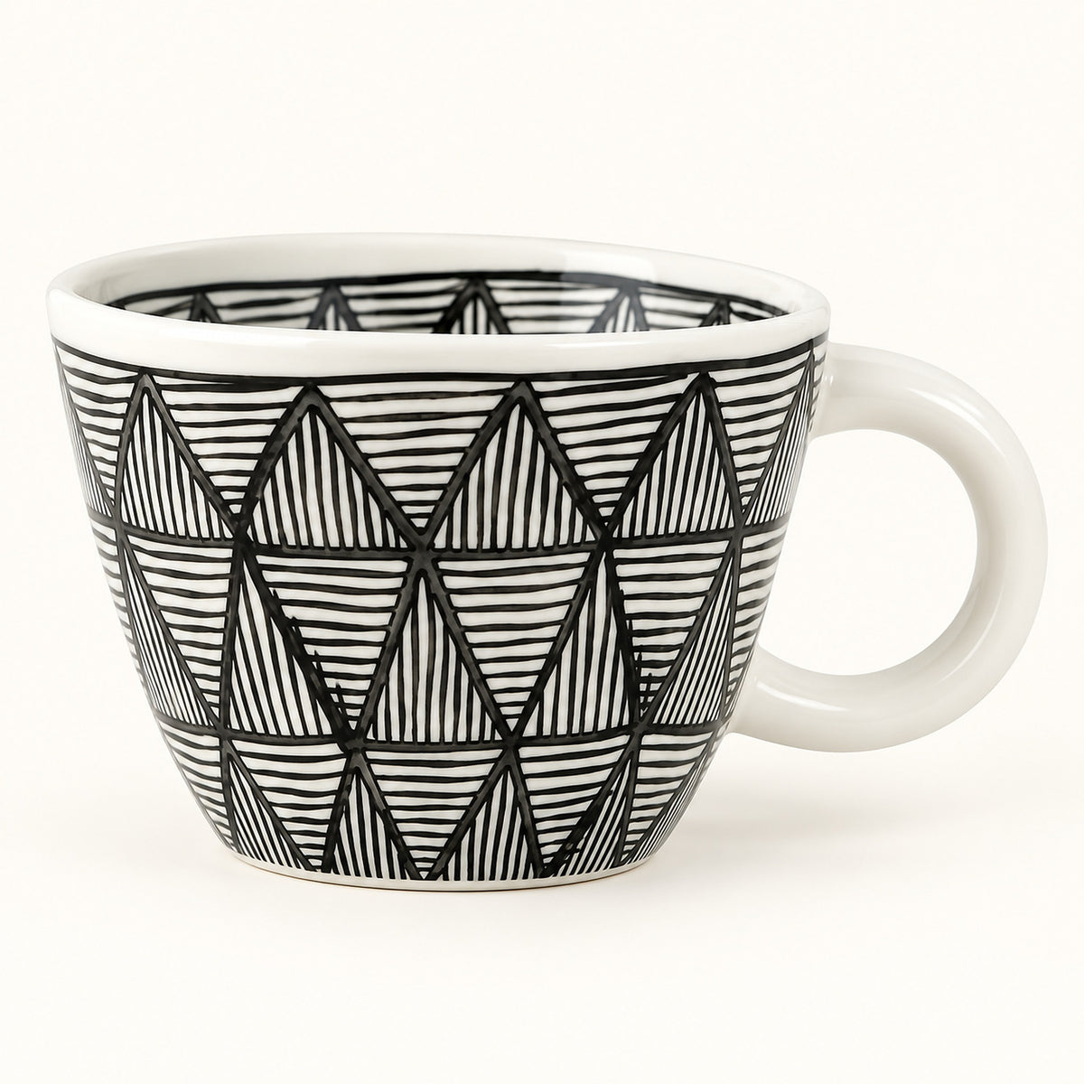 A white ceramic coffee mug with a black hand-drawn geometric triangle pattern, shown on a clean white background.