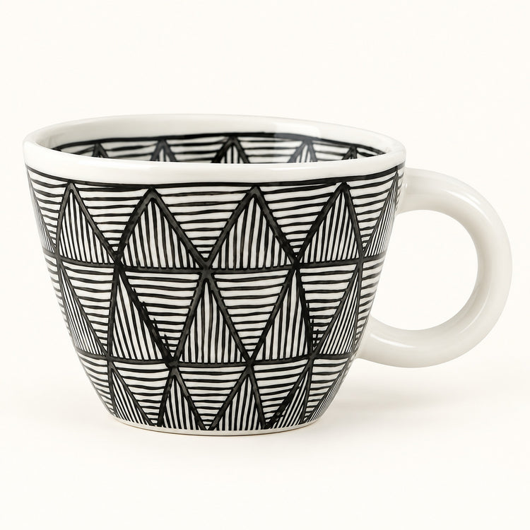 A white ceramic coffee mug with a black hand-drawn geometric triangle pattern, shown on a clean white background.