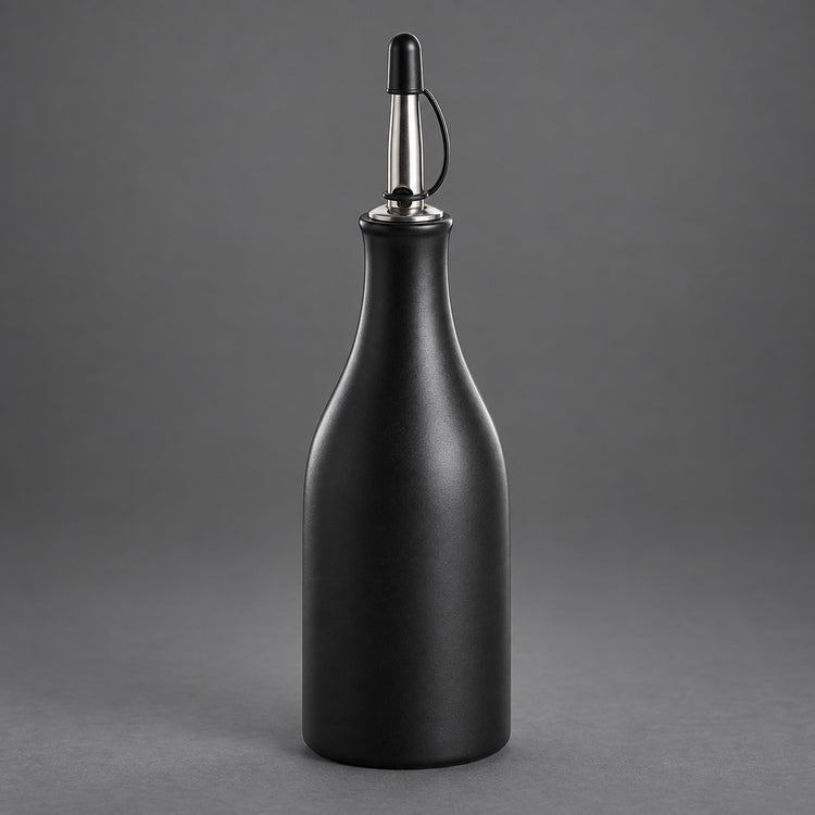 A matte black bottle with a metallic silver and black pour spout, set against a solid gray studio background.