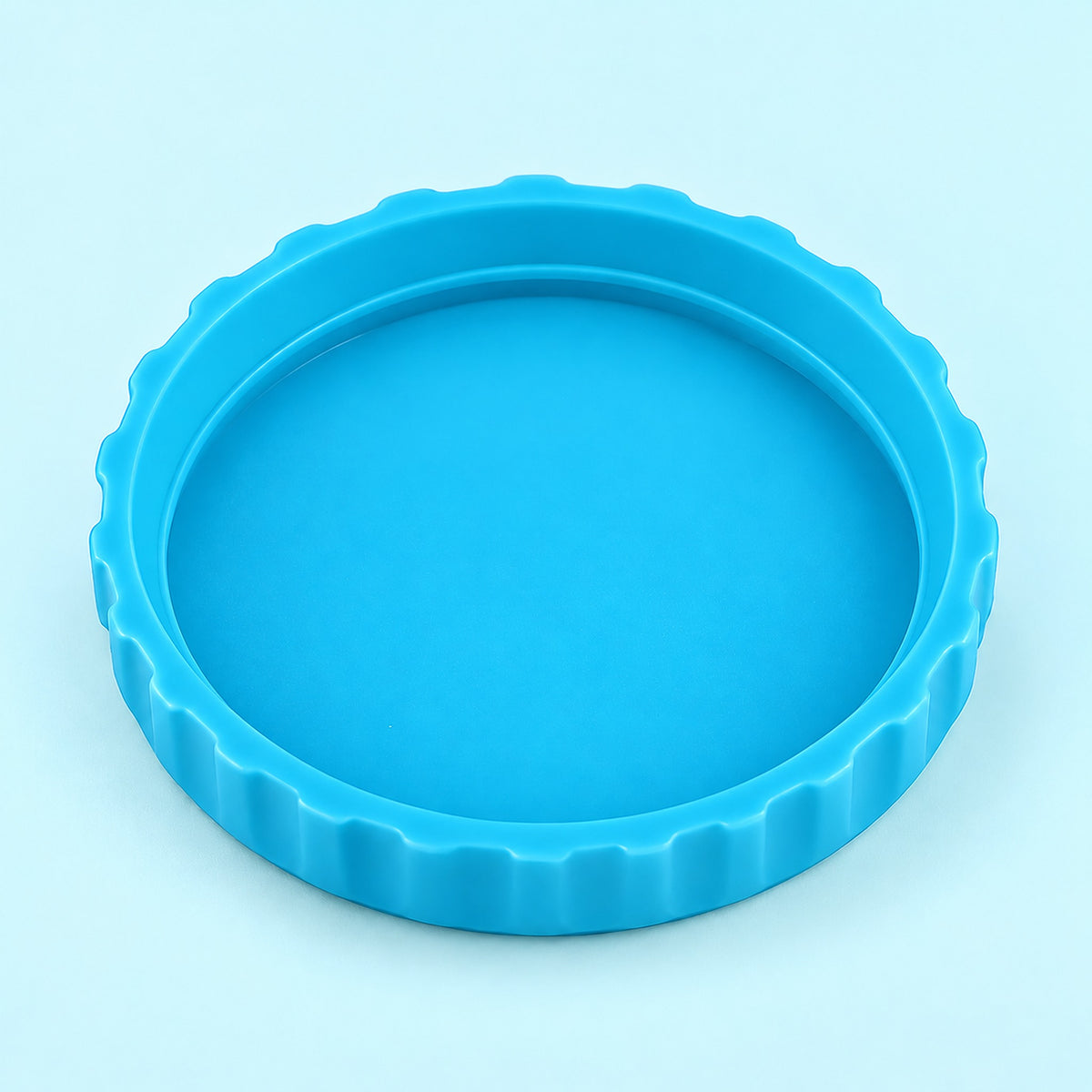 One cyan-blue lid, interior-up studio view on pale cyan.