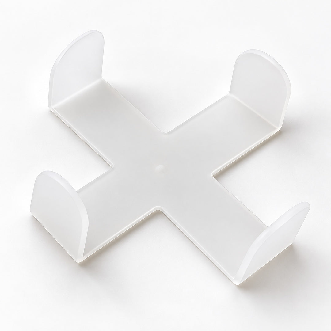 One empty white cross-shaped coaster holder, coasters sold separately.