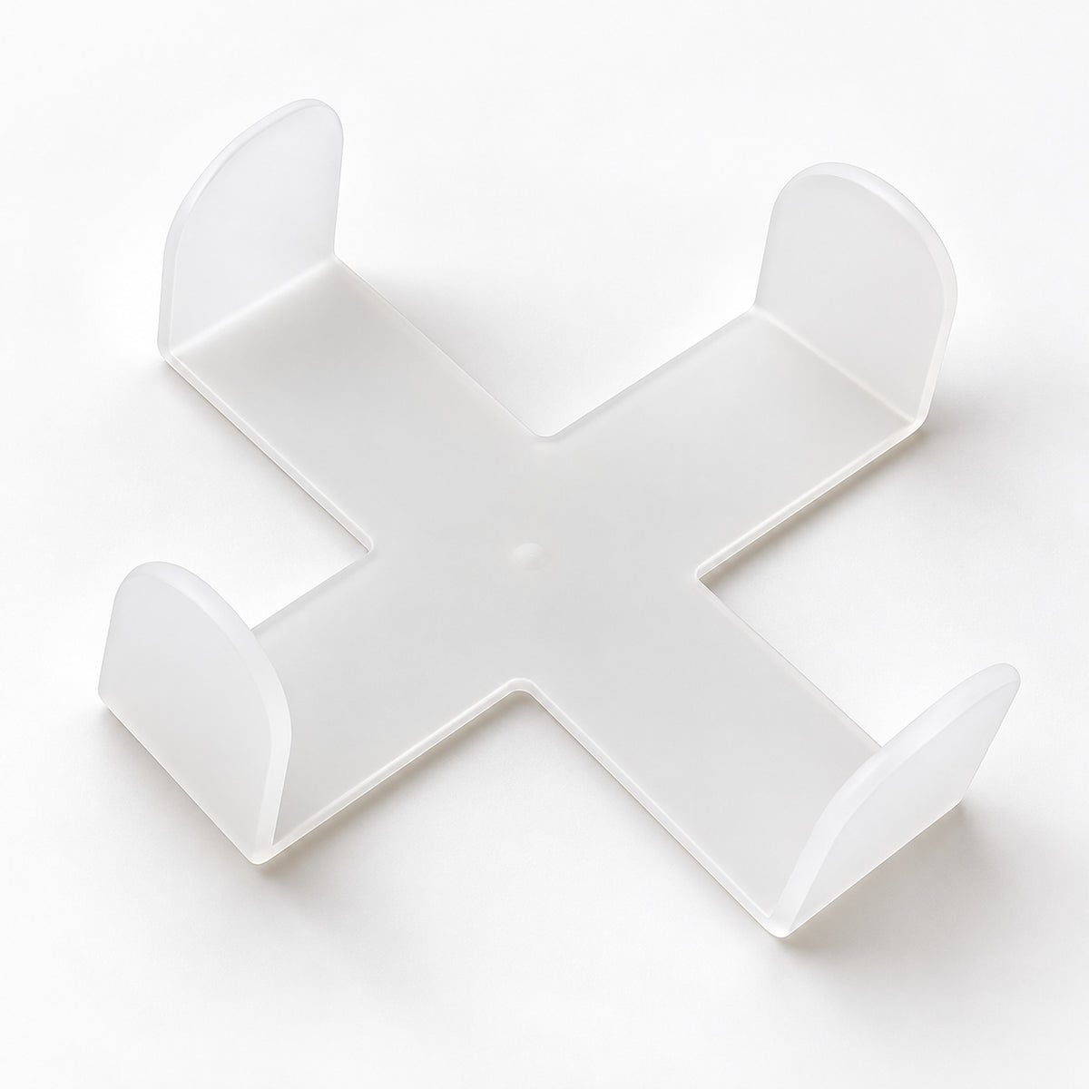 One empty white cross-shaped coaster holder, coasters sold separately.