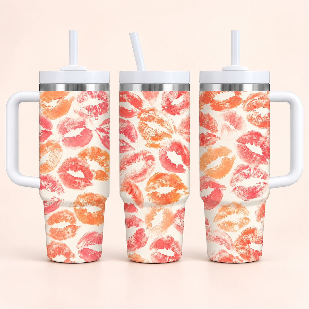 Three handled insulated tumblers with white straws, shown from front and side angles. The tumblers have a repeating lip-print pattern in coral pink, orange, and red on a warm off-white background.
