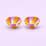 Two yellow purple and white swirl silicone mini bowls, open tops and pedestal bases.