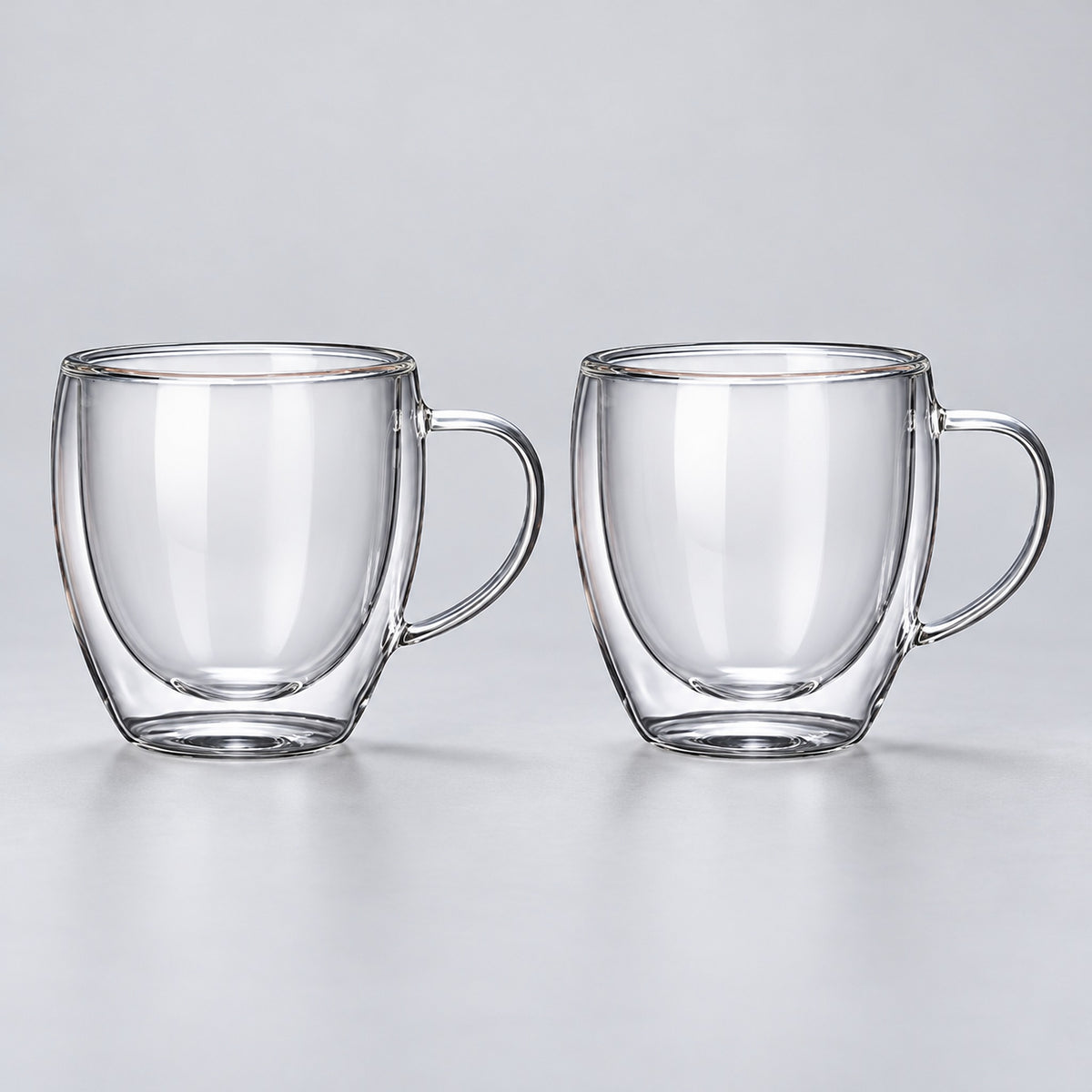 Two empty rounded 250 ml clear double-wall glass mugs with handles.