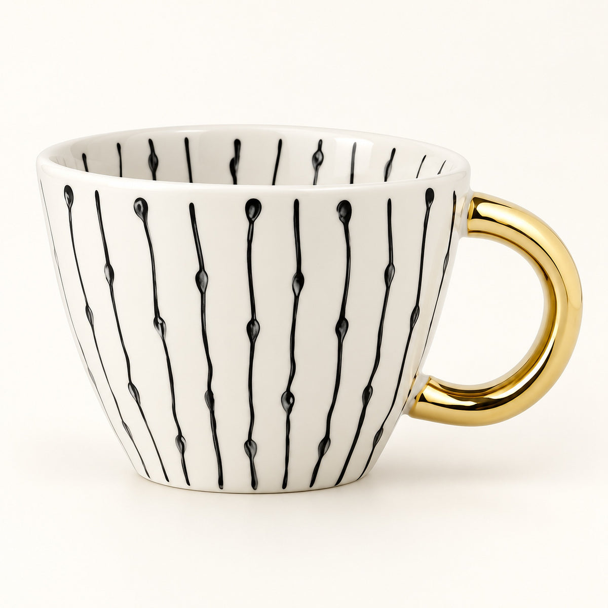 A white ceramic coffee mug with a gold handle and black vertical line patterns, photographed on a clean white background.