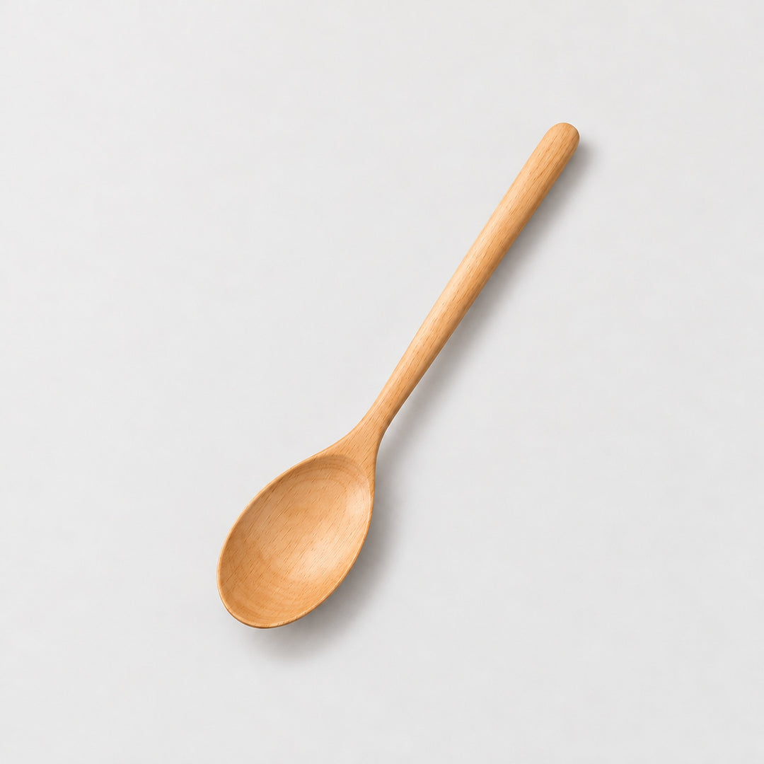 One Camel wood spoon on a light warm-gray studio background.