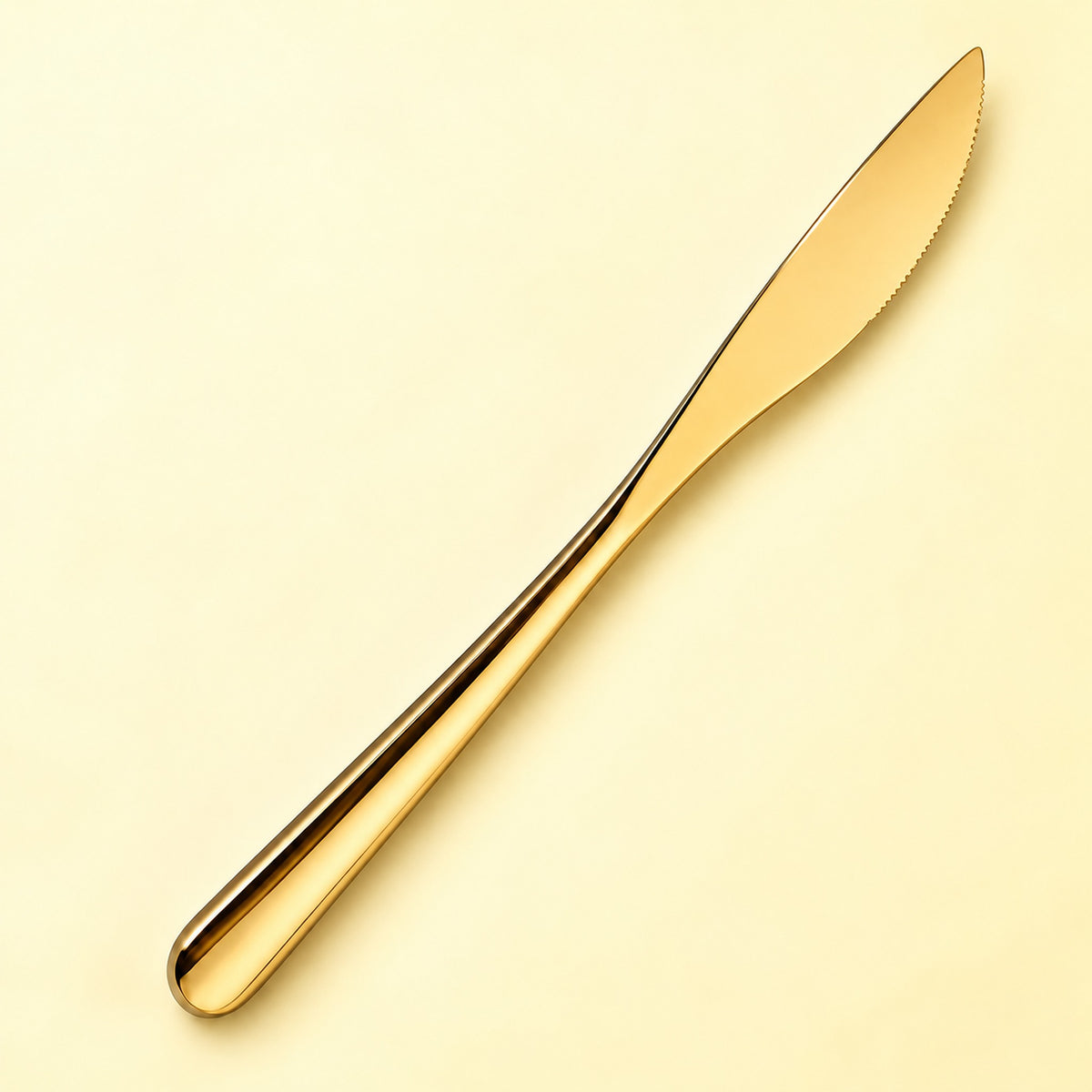 One gold dinner knife on a soft studio background.