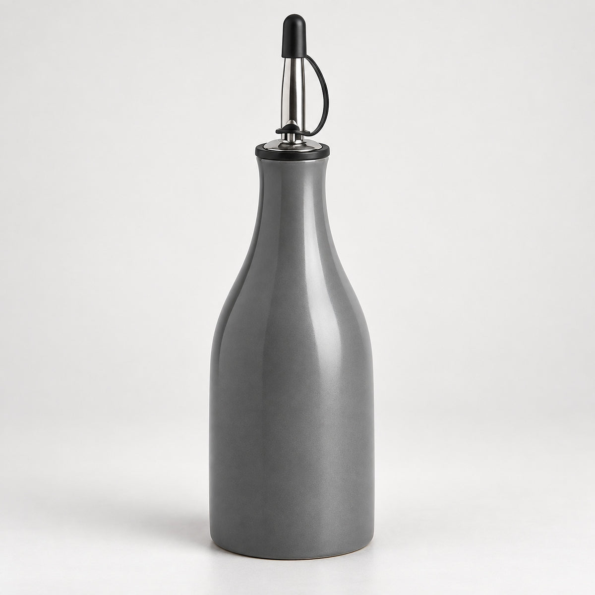 A matte gray ceramic bottle with a pour spout featuring a black plastic cap and a silver metal loop handle, set against a plain light gray background.