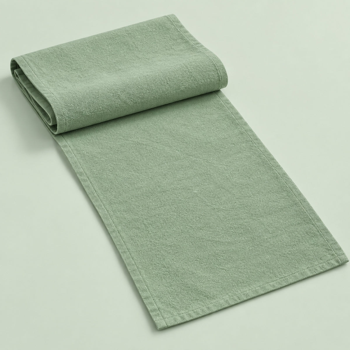 Light Green cotton table runner with sewn edges, folded studio view; choose length separately.