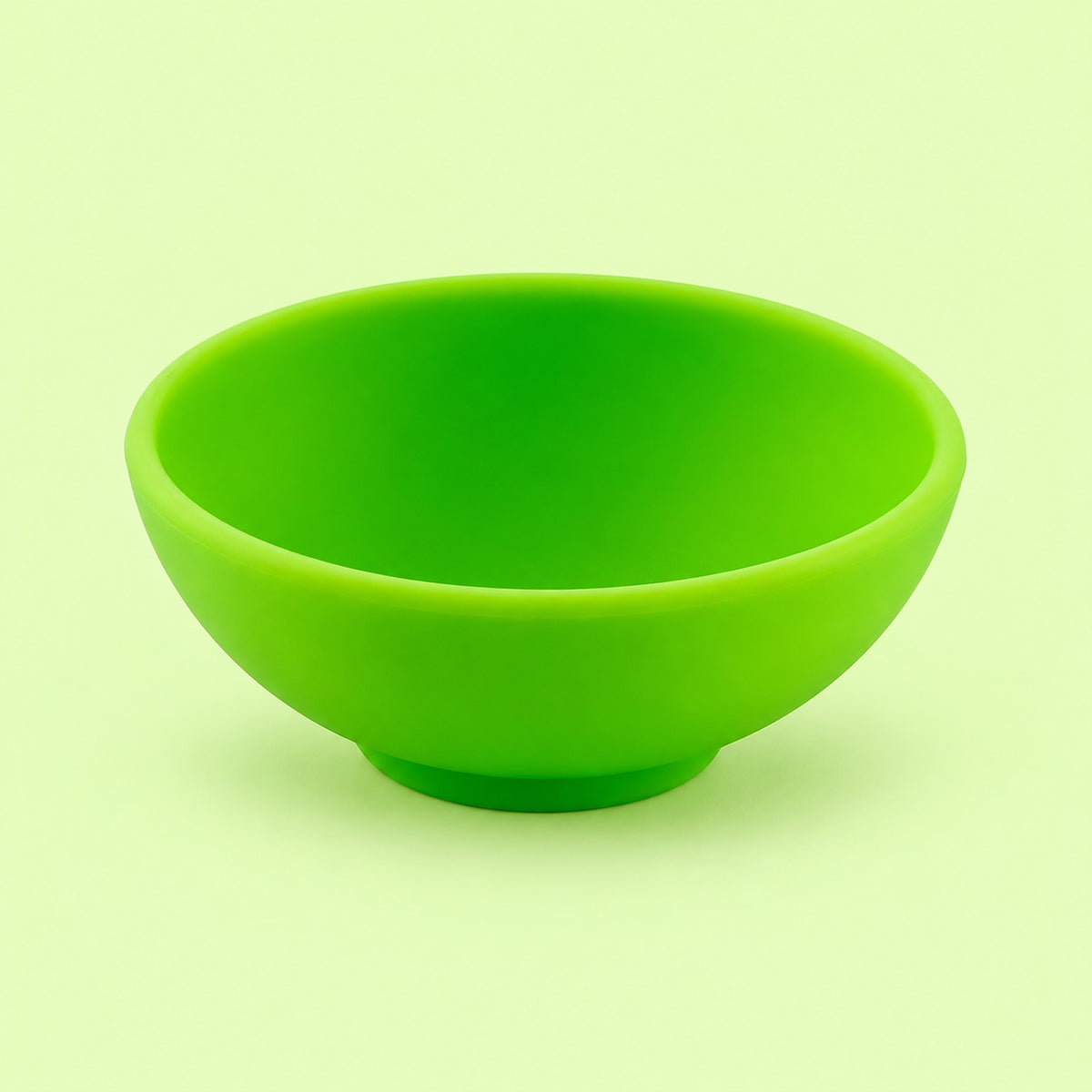 Lime-green mini silicone bowl, single empty piece in studio.